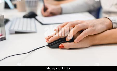 Hands Working Together on a Computer During a Collaborative Office Project Stock Photo