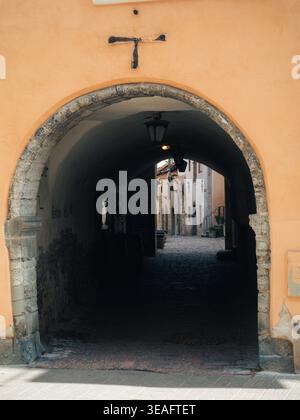 Medieval stone archway passage leading to a cobblestone courtyard in Tallinn Old Town, Estonia, in spring Stock Photo