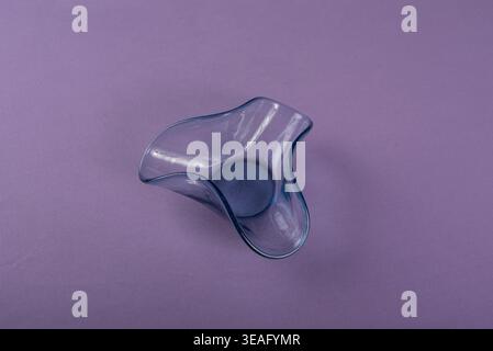 Still life featuring a delicate blue glass bowl against a pale purple background. Soft light emphasizes textures, ideal for designs and visuals relate Stock Photo
