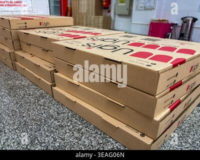 Stacks of cardboard boxes from the classic Ugi's stone-baked pizza on a gray marble counter, an emblem of fast food in Buenos Aires, Argentina. Stock Photo