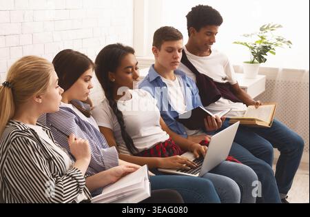 Group of Students Engaged in Study Session in Bright Room With Plants and Natural Light Stock Photo