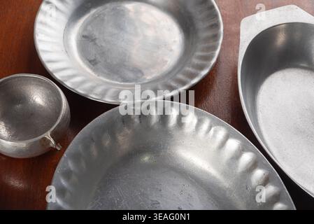 High-angle studio shot showcases brushed aluminum kitchen bowls. Silver tones, textured surfaces. Strong directional light emphasizing form. Ideal vin Stock Photo