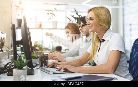Casual business team working on computers in office Stock Photo
