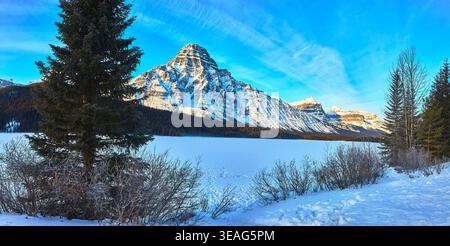 Panoramic Winter Landscape Frozen Lake Snow Covered Mountains and Evergreen Trees Stock Photo