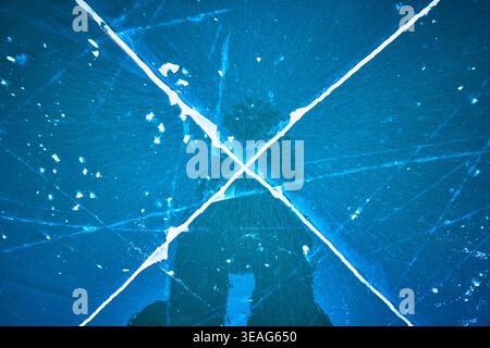 Cracked Ice Pattern on Frozen Lake Surface with Deep Blue Winter Reflections Stock Photo