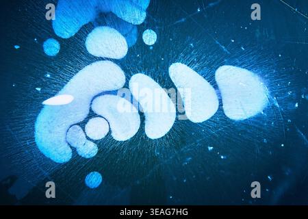 Frozen Methane Bubbles Under Ice on Winter Lake Surface with Blue Abstract Patterns Stock Photo