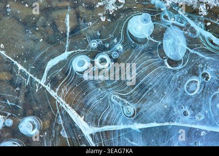 Frozen Lake Surface with Methane Bubbles and Intricate Ice Patterns Winter Close Up Stock Photo