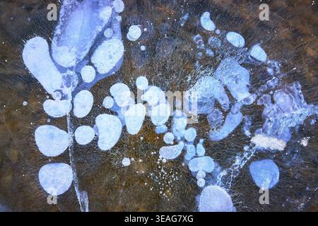 Frozen Methane Bubbles and Cracks in Winter Ice Close Up on Lake Surface Stock Photo