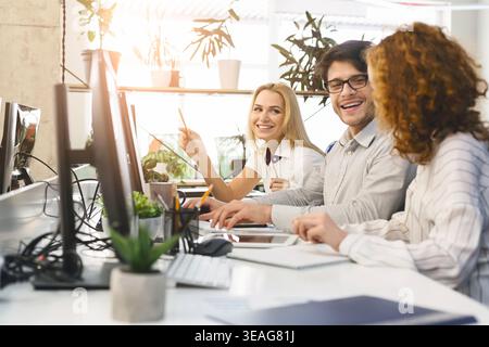 Colleagues Working Together in an Office Space With Plants and Computers During the Day Stock Photo