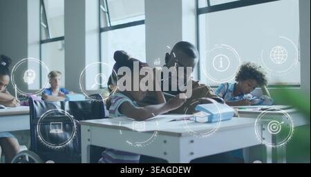 Teacher in dark sweater leaning over student writing in classroom, with blue pencil case and icons Stock Photo
