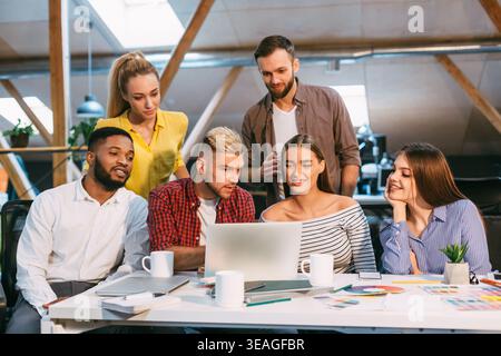 Group Collaborates in Modern Office Discussing Project Details During Daytime Stock Photo
