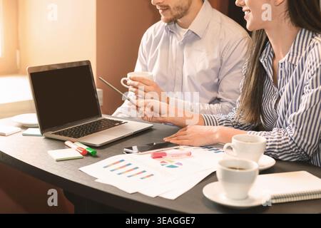 Coworkers discussing strategy, analyzing statistics on laptop Stock Photo