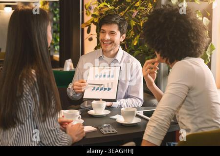 Managers analyzing chart at a business lunch Stock Photo