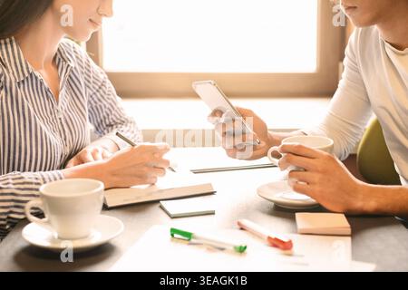 Young people working during business lunch in cafe Stock Photo