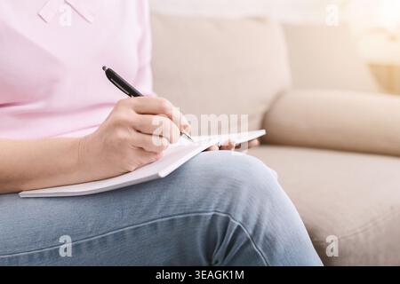 Well organized senior woman with notebook, writing to-do-list Stock Photo