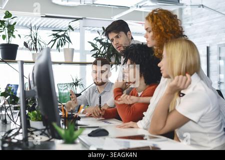 Group of People Working Together on a Project in an Office Setting During Daytime Hours Stock Photo
