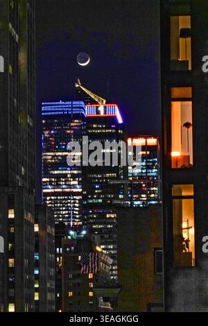 A waxing crescent moon shines over the brightly lit skyscrapers of 1 Penn and Hudson yards, 2026, New York City, USA Stock Photo