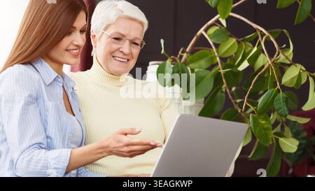 Daughter teaching her senior mother using laptop Stock Photo