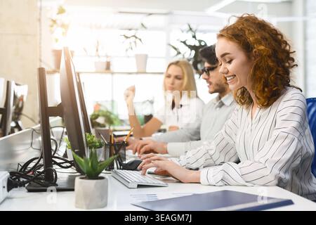 Collaborative Workspace With Professionals Using Computers and Engaging in Teamwork During the Day Stock Photo