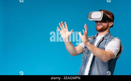 Happy young male touching invisible subject in vr glasses Stock Photo