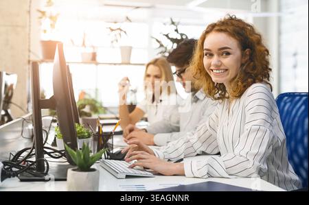 Team Members Collaborate in a Modern Office Setting While Working on Computers During the Afternoon Stock Photo