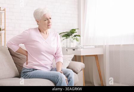 Senior woman suffering from backache at home Stock Photo