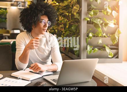 Handsome young man working on laptop and smiling Stock Photo