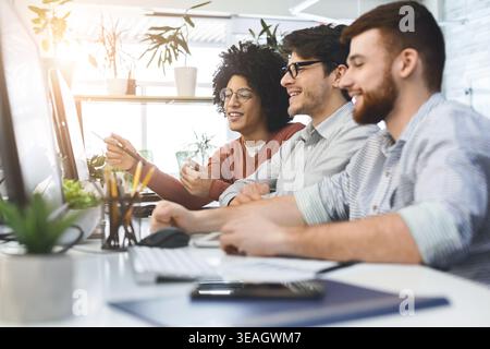 Programmers cooperating at IT company developing apps Stock Photo