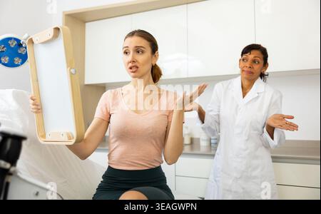 Dissatisfied woman checking result after cosmetology procedure Stock Photo