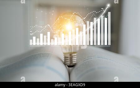 This image showcases a light bulb on an open book, symbolizing ideas and innovation, with a rising graph behind it, representing growth and success in Stock Photo
