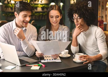 Millennial business team reading contract in cafe Stock Photo