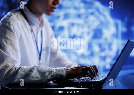 Computer scientist in data center uses artificial intelligence computing simulating human brain through self learning algorithms. System administrator with laptop working with AI deep neural networks Stock Photo