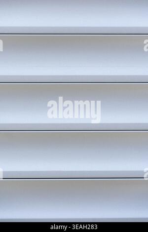 Close-up of Clean Vinyl or Aluminum Siding Texture with Smooth, Even Surface, Monochromatic Background of Light Gray Horizontal Panels and Grooves for Stock Photo