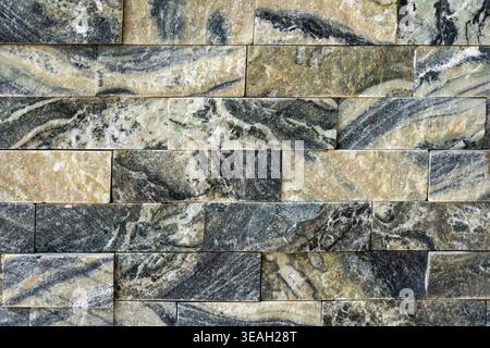 Luxury Stacked Marble Stone Wall Veneer Texture with Black, Gray, and Gold Veining Stock Photo