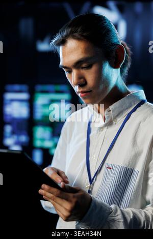 Tech support worker between server room hardware providing processing resources for companies worldwide. Skillful developer fixes data center supercomputers used for storing large databases Stock Photo