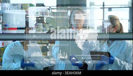 Analyzing research data, four scientists in lab coats and gloves studying holographic graphs Stock Photo