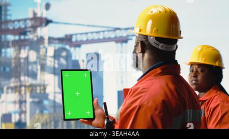 Isolated screen tablet used by offshore rig specialist monitoring operations on oil platform deck. Drilling rig employee reviewing energy operations using chroma key device, close up Stock Photo