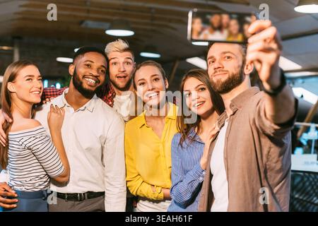 Group of Friends Taking a Selfie in a Modern Cafe During a Lively Gathering Stock Photo