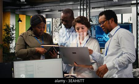 Engineering team in startup office working with AI technology driving market innovation. Tech agency coworkers applying machine learning to optimize operations and efficiency, camera A Stock Photo