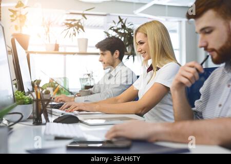 Diverse young people using office computers at coworking Stock Photo