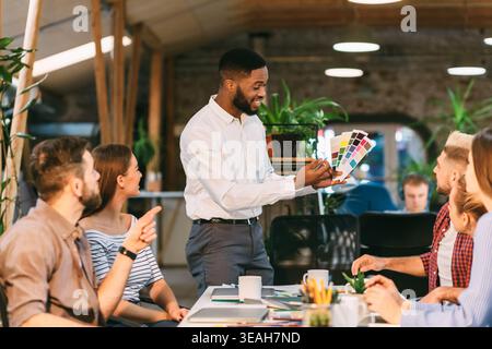 Engaging Design Meeting in a Creative Workspace With Diverse Team Discussing Color Options Stock Photo