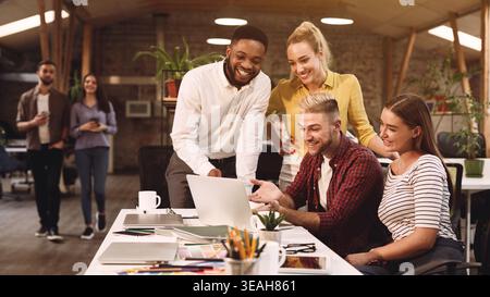 Young colleagues discussing ideas in coworking office Stock Photo