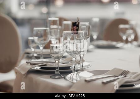 Minimal Fine Dining Place Setting With Stacked Plates, Crystal Glasses And Neatly Folded Napkin, Muted Palette And Soft Focus Background Suggesting Stock Photo