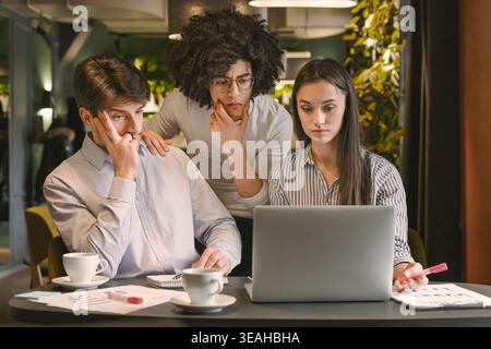 Three Colleagues Collaborating on a Project at a Modern Workspace Stock Photo