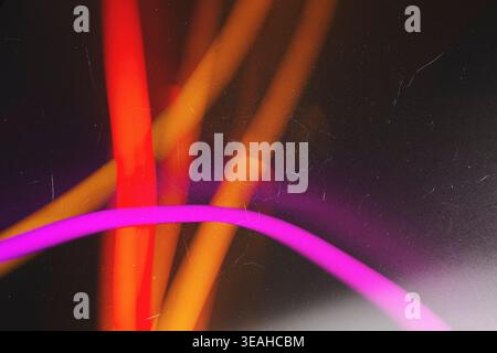 Vibrant neon pink and orange light trails with distressed film texture Stock Photo