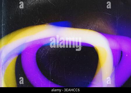 Abstract blurred neon light trails in purple and yellow on dark dusty film texture Stock Photo