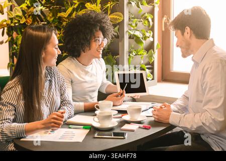 Team Members Collaborate in a Bright Office Setting During a Productive Brainstorming Session Stock Photo