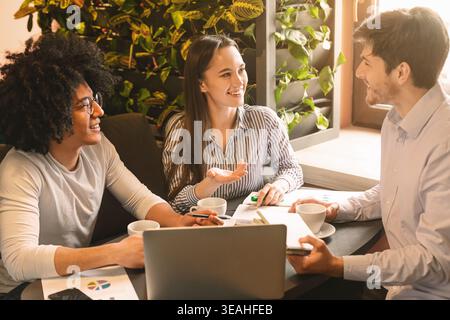 Young team showing presentation to partner during business lunch Stock Photo