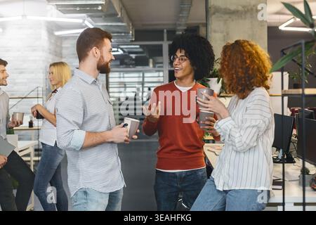 Diverse millennials enjoying communication in modern office Stock Photo
