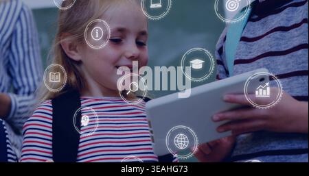 Smiling girl in striped-shirt with backpack using white tablet in class near green chalkboard icons Stock Photo